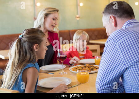 Famiglia di parlare mentre godendo antipasto al tavolo nel ristorante Foto Stock
