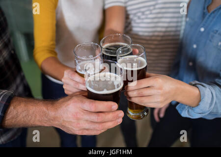 Tagliate le mani degli amici di bevande di tostatura in fabbrica Foto Stock