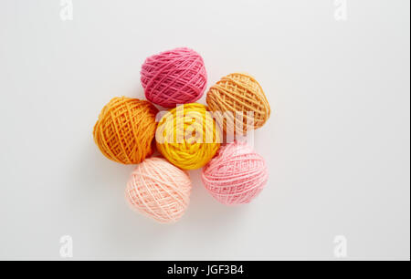 Filati per maglieria a sfere in rosa e il tono di colore giallo. Filato colorato su uno sfondo bianco. Matasse di filo di lana per maglieria. Foto Stock