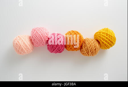 Filati per maglieria a sfere in rosa e il tono di colore giallo. Filato colorato su uno sfondo bianco. Matasse di filo di lana per maglieria. Foto Stock