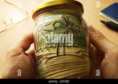 Vaso con dollari e foto di Isola su un lato. I soldi per il viaggio e le vacanze. Foto Stock