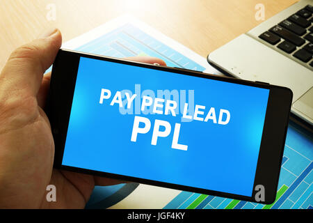 Mano azienda smartphone con parole Pay Per Lead PPL. Foto Stock