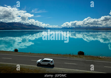 SUV sull'autostrada statale 8, e Aoraki/Mount Cook si riflette nel Lago Pukaki, Mackenzie Country, Canterbury, Isola del Sud, Nuova Zelanda Foto Stock