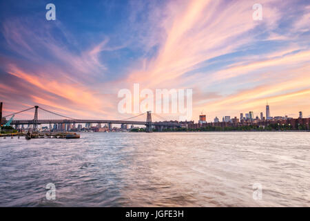 New York tramonto su East River e il Williamsburg Bridge sul retro Foto Stock