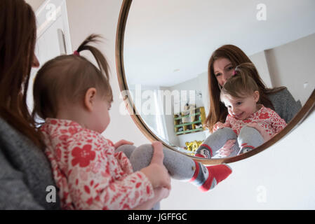 La riflessione di soggetti di razza caucasica la madre e il bambino la figlia a specchio Foto Stock
