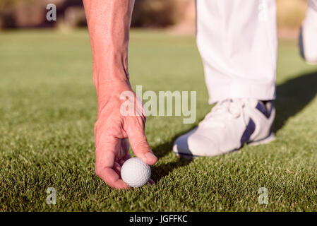 Golfista ispanica posizionando la pallina da golf sul raccordo a T Foto Stock