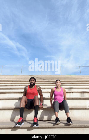 L uomo e la donna facendo tricipiti salse sulla bleachers Foto Stock