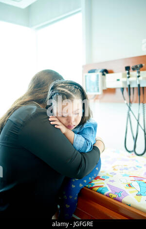 Madre ispanica, abbracciando la figlia con la sindrome di Down Foto Stock