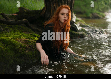 Grave Caucasian woman standing Waist Deep in acqua Foto Stock