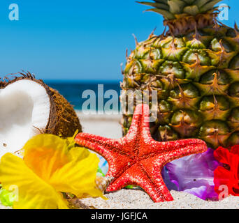 L'ananas e noci di cocco in riva al mare in una limpida giornata estiva Foto Stock