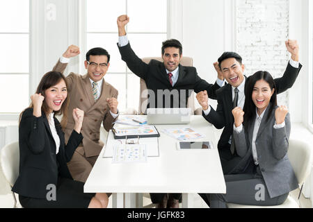 Gruppo di etnia muti la gente di affari del successo del team conquista con il braccio sollevato per celebrare un buon lavoro in ufficio. La gente di affari team togethern Foto Stock