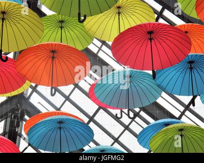 Multi ombrelloni colorati appesi da un soffitto in un centro commerciale Foto Stock