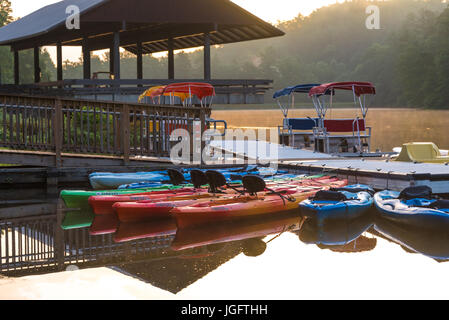 Colorato i kayak e barche a remi che riflette ancora acqua di lago Trahlyta presso sunrise in Vogel State Park, accoccolato tra le Blue Ridge Mountains. Foto Stock