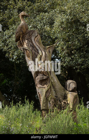 Tall scolpita scultura lignea di uccello su un albero con una badger e riccio in giardini di Clevedon Hall Hotel, Clevedon vicino a Bristol, Somerset, Regno Unito. Foto Stock