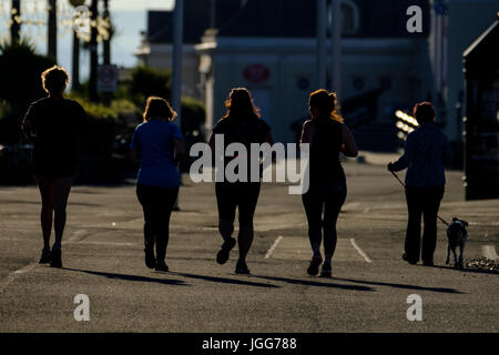 Worthing, Regno Unito. 7 Luglio, 2017. Una tranquilla mattina calda a Worthing, Regno Unito. 07 Luglio, 2017. Un gruppo di donne jog al sole del mattino, passando un dog walker. Foto di credito: Julie Edwards/Alamy Live News Foto Stock