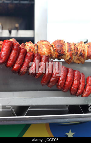 Il chorizo salsicce e polli arrosto su carbone di legna spiedo girarrosto barbecue Foto Stock