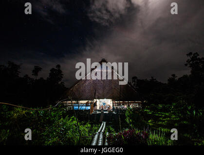 MENTAWAI persone, a ovest di Sumatra, SIBERUT ISOLA, Indonesia - 03 OKTOBER 2011: casa tradizionale Mentawai tribù nella giungla di notte. Foto Stock