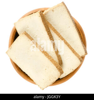 Tofu affumicato fette nella ciotola di legno. Tofu. Coagulato di latte di soia, premuto nella ditta blocchi di bianco. Componente di cucina asiatica. Sostituto della carne. Foto Stock