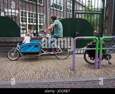 Delft, Paesi Bassi, 30 giugno 2017: Padre attende con carico bici alla scuola materna nella cittadina olandese di Delft Foto Stock