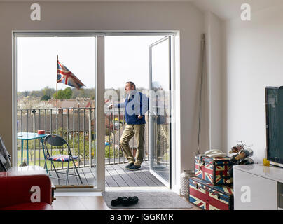 Ritratto di residenti sul suo balcone privato con bandiera britannica. Bruyn's Court, Sud Ockendon, Regno Unito. Architetto: Campana architetti Phillips, 201 Foto Stock