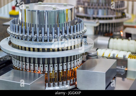 Ispeziona ampolle e fiale per le particelle nel liquido e contenitore di difetti. La produzione farmaceutica. Foto Stock