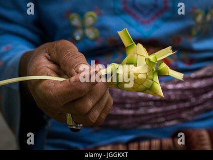 Vecchia donna preparare offerte in un tempio, isola di Bali, Tampaksiring, Indonesia Foto Stock