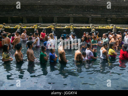 Adoratori di prendere un bagno nella piscina di depurazione a Tirta Empul temple, isola di Bali, Tampaksiring, Indonesia Foto Stock