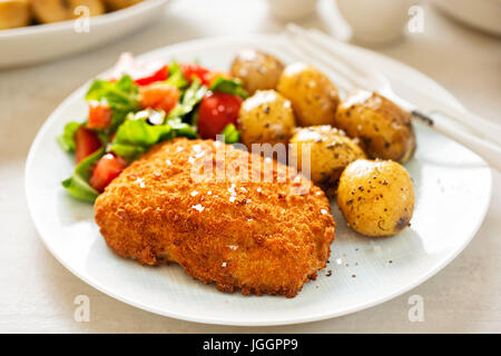 Panato tradizionale filetto di merluzzo con baby patate ed insalata Foto Stock