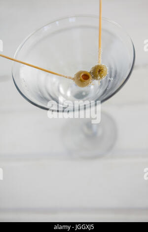 Close up di olive verdi in vodka martini sulla tabella Foto Stock
