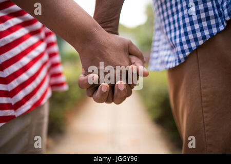 Immagine ritagliata della coppia senior tenendo le mani e piedi in cantiere Foto Stock