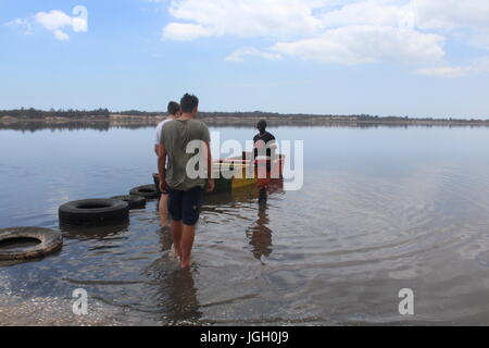 Due turisti e la loro guida pronto per una gita in barca sul Lago Retba, Lago Rosa, Lac Rose, al di fuori di Dakar in Senegal Foto Stock