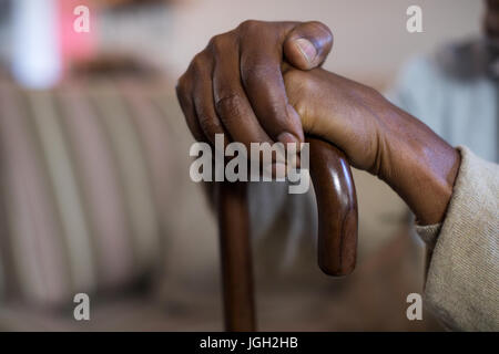 Immagine ritagliata di senior uomo con bastone da passeggio a casa Foto Stock