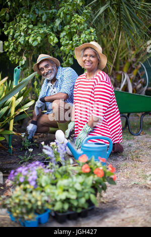 Ritratto di sorridente giovane piantagione mentre giardinaggio in cantiere Foto Stock