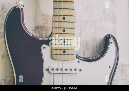 Sbiadita Chitarra elettrica su un dipinto di Sfondo legno Foto Stock