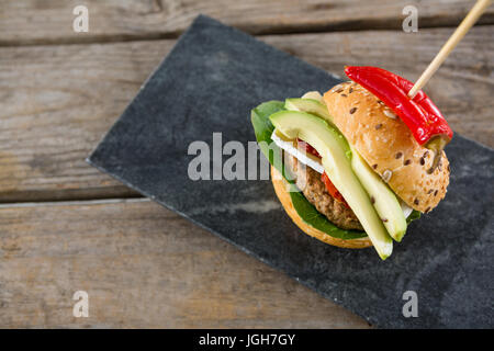 Vista aerea di Burger con peperoncino jalapeno sull'ardesia al tavolo di legno Foto Stock