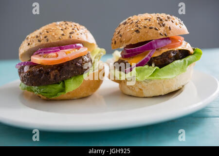 Close up di hamburger nella piastra sulla tavola Foto Stock