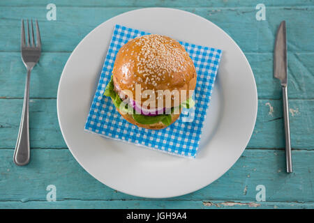 Vista aerea di burger il tovagliolo in piastra a tavolo in legno Foto Stock
