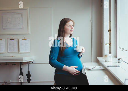 Premurosa donna incinta avente il caffè nel ristorante Foto Stock