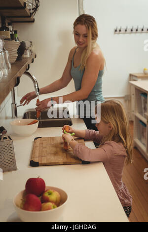 Figlia di madre aiutare in cucina a casa Foto Stock