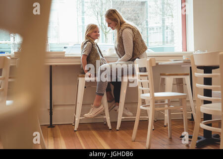 Sorridente madre e figlia divertirsi in un ristorante Foto Stock
