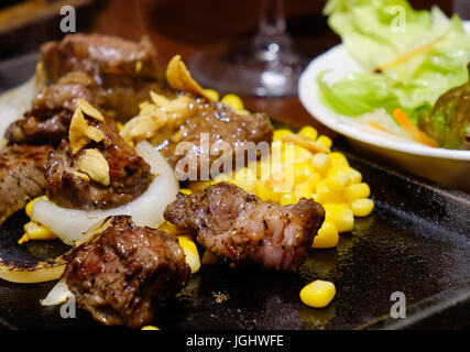 Bistecca di manzo con salsa di peperoni e mais sul tavolo. Close up. Foto Stock