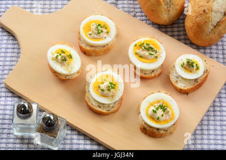 Hard Boiled Omega 3 uova organiche sezioni sul grano intero baguette con la maionese e erba cipollina Foto Stock