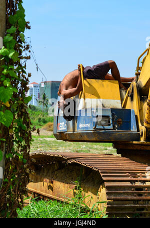 Delhi, India - Mar 9, 2017. Un indiano giovane uomo facendo esercizi Yoga sulla costruzione macchina al giorno di sole a Delhi, India. Foto Stock
