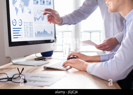 Due persone analizzando il mercato azionario la strategia di investimento con indicatore di prestazioni chiave sul cruscotto finanziario e business intelligence su computer Foto Stock