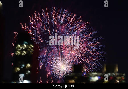 Striature e raffiche di coloratissimi botti da fuochi d'artificio oltre lo skyline di New York Foto Stock