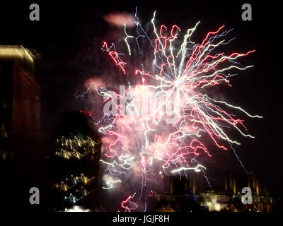 Striature e raffiche di coloratissimi botti da fuochi d'artificio oltre lo skyline di New York Foto Stock