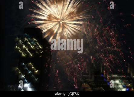 Striature e raffiche di coloratissimi botti da fuochi d'artificio oltre lo skyline di New York Foto Stock