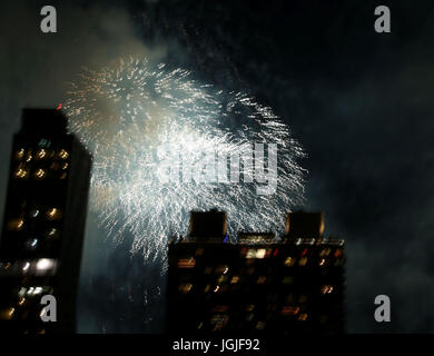 Striature e raffiche di coloratissimi botti da fuochi d'artificio oltre lo skyline di New York Foto Stock