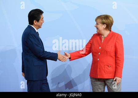 Amburgo, Germania. 07 Luglio, 2017. Il cancelliere tedesco Angela Merkel si compiace Primo Ministro giapponese Shinzo Abe all'inizio del primo giorno del Vertice G20 riuniti il 7 luglio 2017 ad Amburgo, in Germania. Credito: Planetpix/Alamy Live News Foto Stock