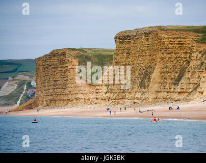 Burton Bradstock, Dorset, Regno Unito. 8 luglio 2017. Le persone che si godono la spiaggia con il famoso West Bay scogliere come uno sfondo come il soleggiato clima caldo prosegue sulla costa sud. Credito: Dan Tucker/Alamy Live News Foto Stock